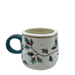 Side view showing the holly pattern wrapping around the cup and the green handle