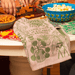I Have A Bit Of A Plant Problem tea towel on table, green woven plant design, lifestyle photo.