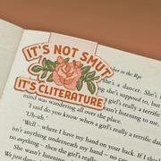 It's Not Smut It's Cliterature magnetic bookmark marking a page in a book