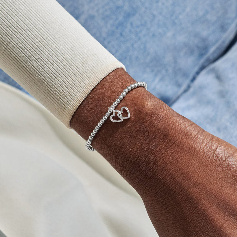 Silver-plated beaded Bracelet worn on wrist with interlinked open heart charms for friendship gift