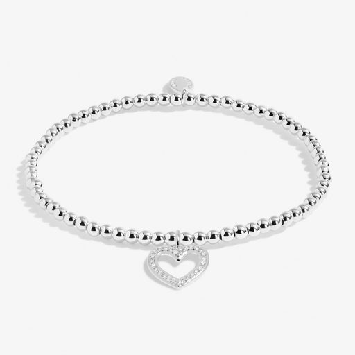 Joma A Little Happy Birthday Sister Bracelet laid flat, silver-plated beaded stretch Bracelet with heart charm.