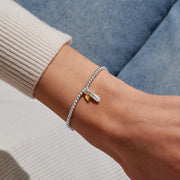 Silver beaded Bracelet worn on wrist with feather charm and gold heart charm for thinking of you gift