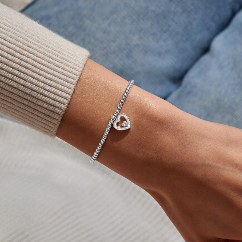 Silver-plated beaded Bracelet worn on wrist with sparkling open heart charm and centre heart crystal