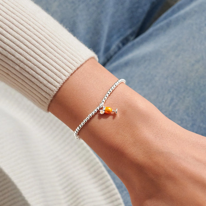Silver-plated beaded Bracelet worn on wrist with orange spritz glass charm and citrus slice detail