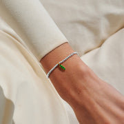 Silver-plated beaded Bracelet worn on wrist with green pea pod charm and gold-tone outline