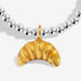 Close-up of gold-tone croissant charm on silver-plated beaded Bracelet