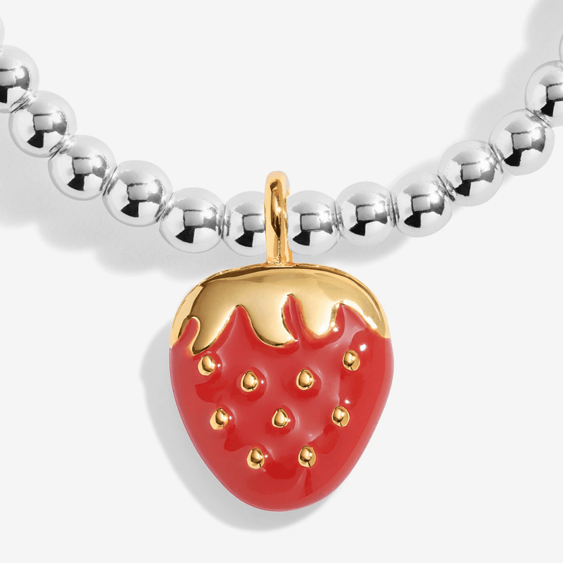 Close-up of red strawberry charm with gold-plated details