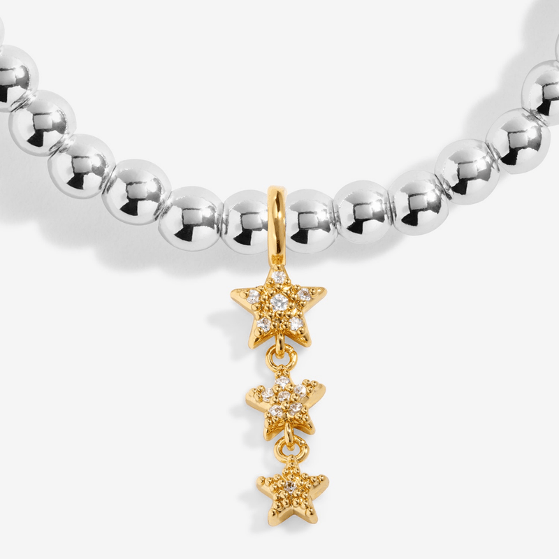 Close-up of the sparkling gold-plated star charm on a Joma bracelet