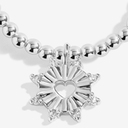 Close-up of sparkling silver starburst charm with open-heart centre