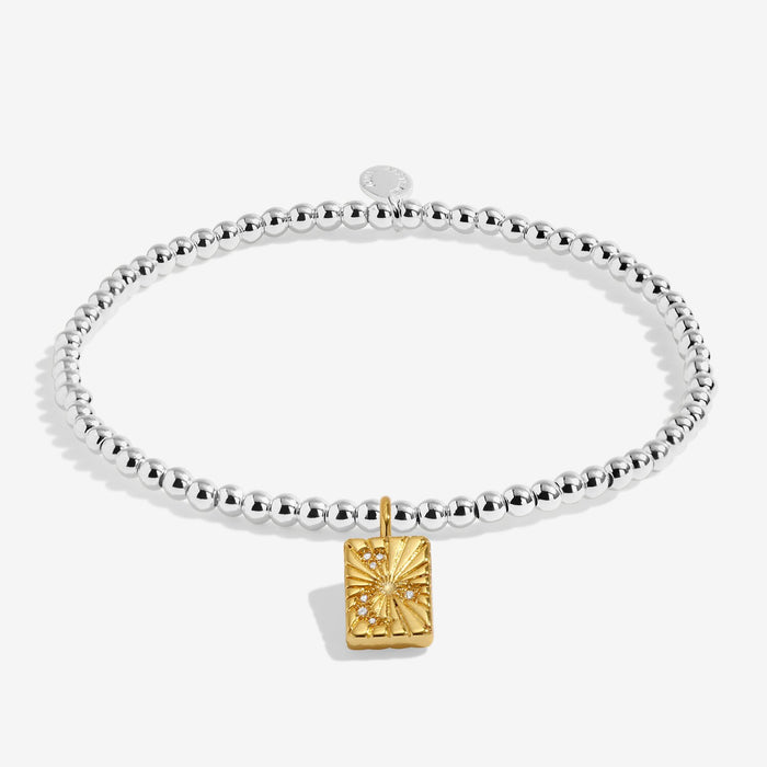 Joma stretch Bracelet with silver beads and gold starburst charm displayed on a white background