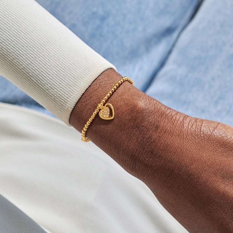 Gold-plated Joma Jewellery beaded Bracelet worn on wrist with open heart frame and sparkly heart charm, First My Mum Forever My Friend.