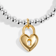 Close-up of the gold-plated heart padlock charm on a Joma bracelet