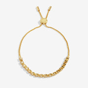Joma Jewellery gold‑plated slider bracelet with row of bezel‑set clear crystals, product shot on white background.
