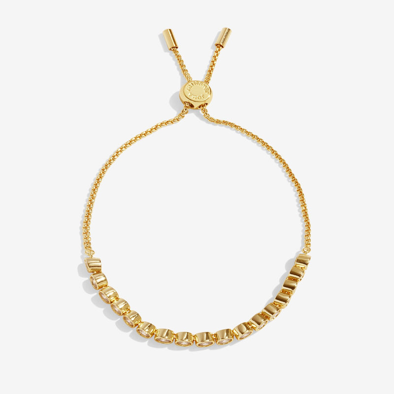 Joma Jewellery gold‑plated slider bracelet with row of bezel‑set clear crystals, product shot on white background.
