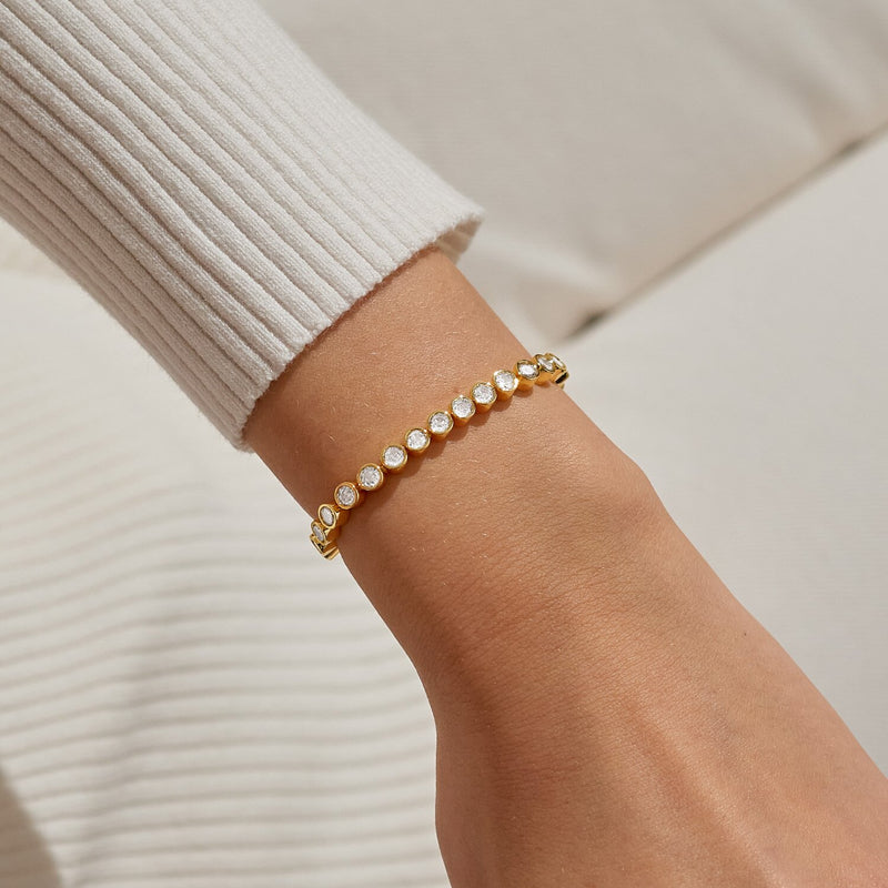 Gold crystal slider bracelet styled on wrist, displaying brilliant stones and smooth slider for a personalised fit.
