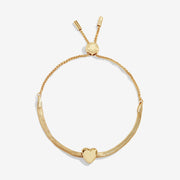 Joma Jewellery gold‑plated herringbone slider bracelet with polished heart slider charm, product shot on white background.
