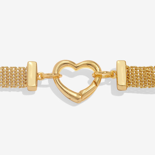 Close‑up of the gleaming gold heart carabiner clasp joining the fine woven mesh links on the bracelet.
