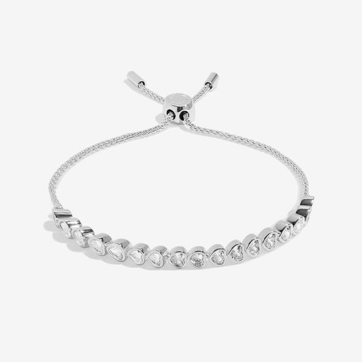 Angled view highlighting the adjustable slider clasp and sparkling crystal row on the polished silver bracelet.
