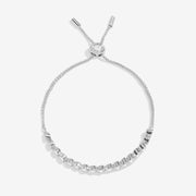 Joma Jewellery silver‑tone slider bracelet with bezel‑set clear crystals, product shot on white background.
