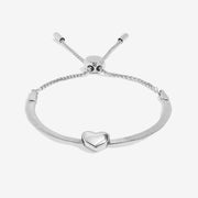 Angled view highlighting adjustable box‑chain slider clasp and curved heart charm on the sleek silver bracelet.
