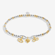 Two‑tone silver & gold beaded bracelet with three mixed‑metal charms – heart, infinity, interlocking hearts – on white background.

