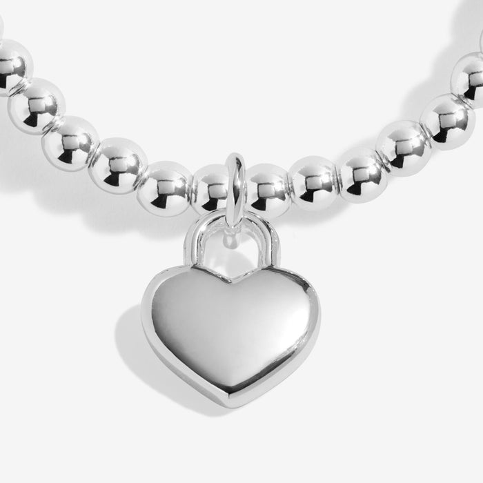 Close-up of silver heart padlock charm on silver-plated beaded stretch Bracelet