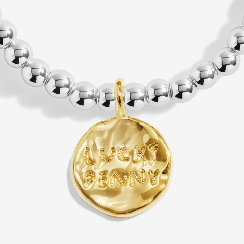 Close-up of gold-plated Lucky Penny charm on Joma Jewellery bracelet