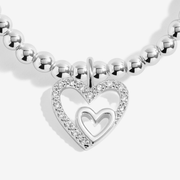 Close-up of the double-heart charm on the Joma Mother and Daughter Bracelet