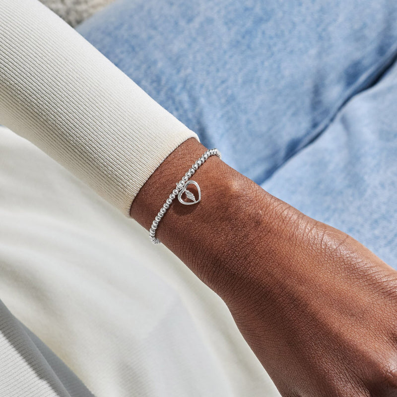 Silver-plated Joma Jewellery beaded Bracelet worn on wrist with open heart charm and angel feather detail, Mums Are Angels In Disguise.