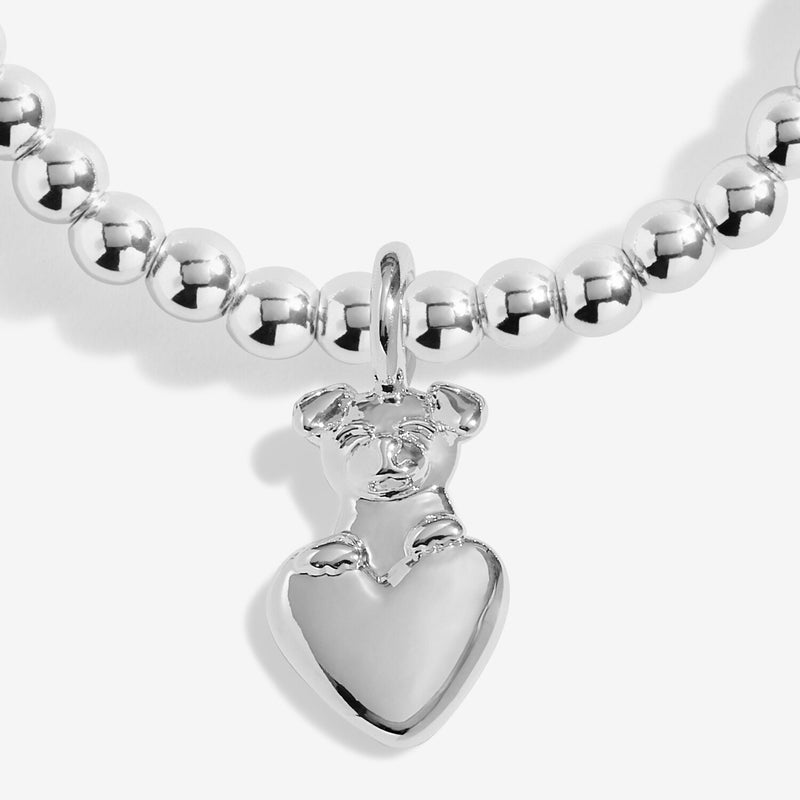 Close-up of silver dog charm hugging a heart on silver-plated beaded stretch Bracelet