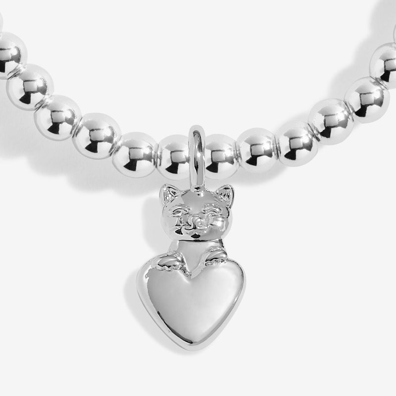 Close-up of silver cat charm hugging a heart on silver-plated beaded stretch Bracelet
