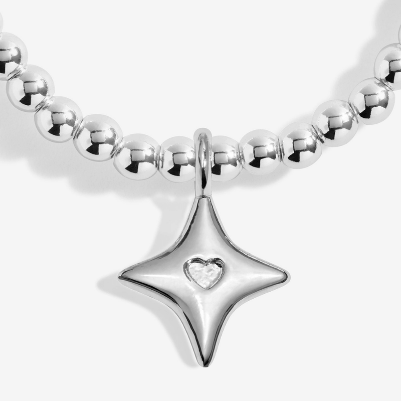 Close-up of the silver-plated star bracelet charm with a small heart detail