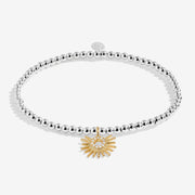 Joma stretch Bracelet with silver beads and gold sunburst charm displayed on a white background