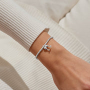 “Christmas Cheers” bracelet styled on wrist – sparkling clinking flutes charm adds celebration sparkle to holiday outfits.
