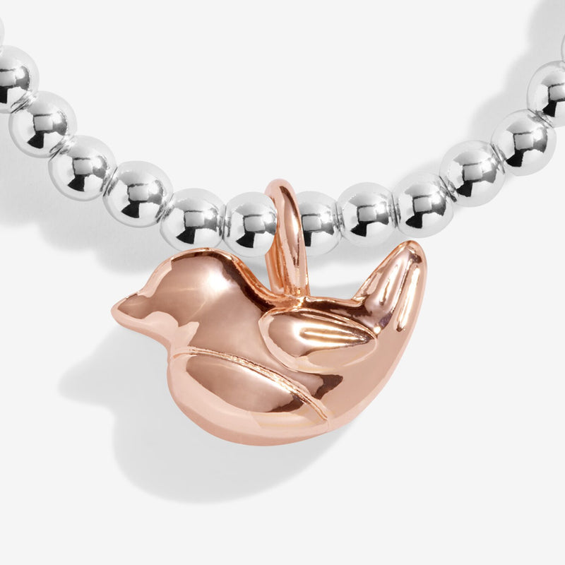 Detailed view of the highly polished rose‑gold robin bird charm dangling from petite silver beads on the Christmas Robin bracelet.

