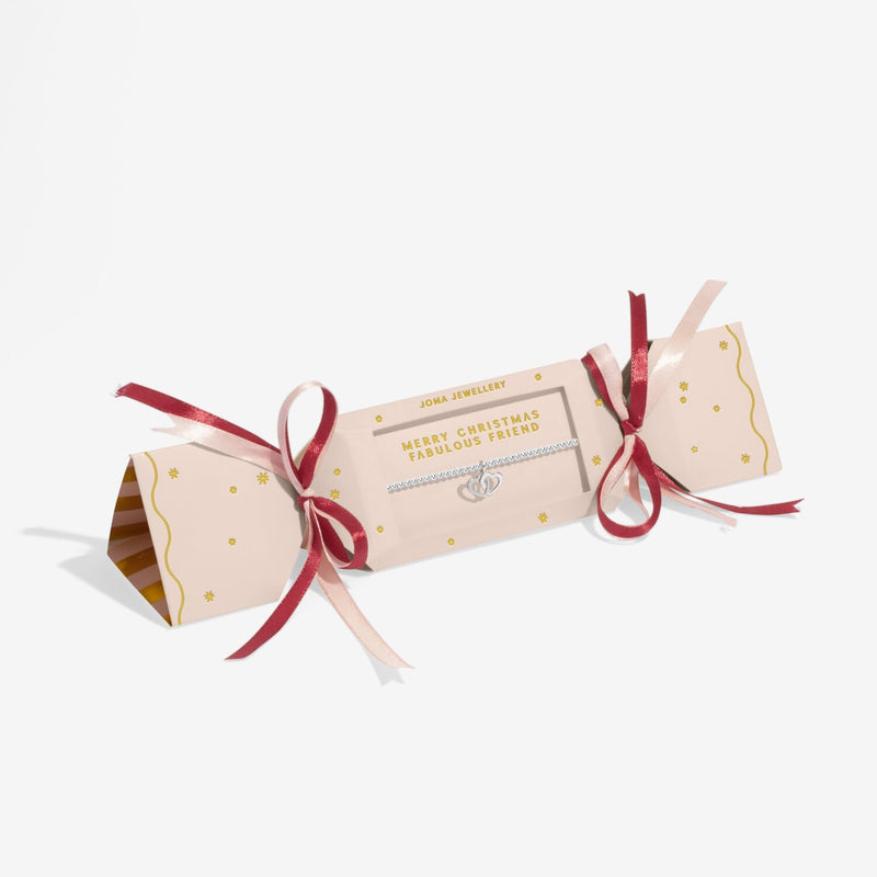 Blush and wine Christmas‑cracker gift box presenting Joma Jewellery Fabulous Friend interlocking hearts bracelet.