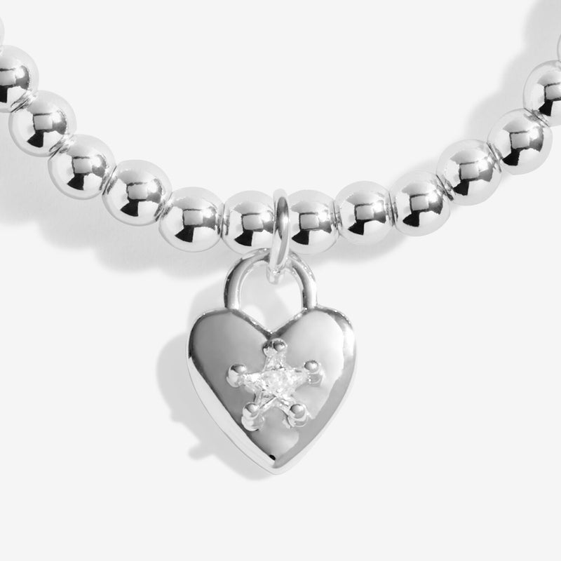Close-up of Joma friendship heart bracelet with crystal star detail