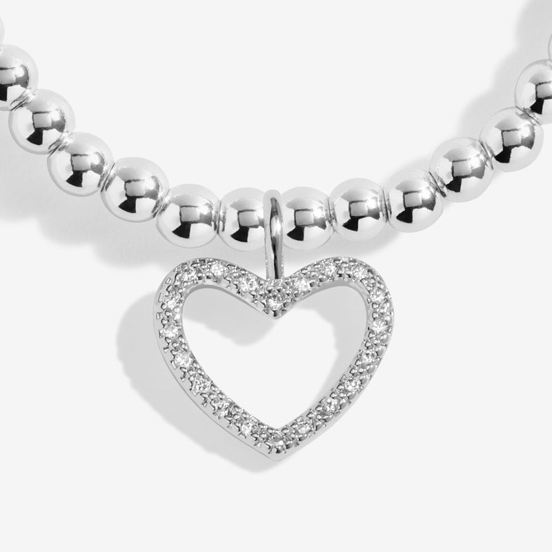 Close‑up of Joma Jewellery “Merry Christmas” bracelet pavé heart charm on polished beads – perfect stocking‑filler bracelets for women.
