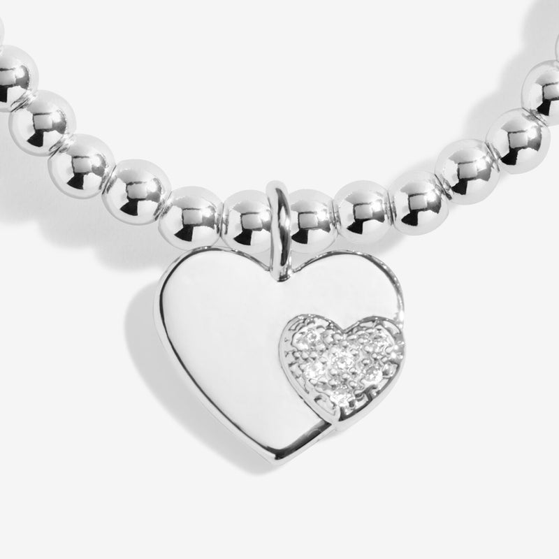 Close‑up of double‑heart charm on Joma Jewellery “Merry Christmas Wonderful Mum” bracelet – sparkling Christmas jewellery.

