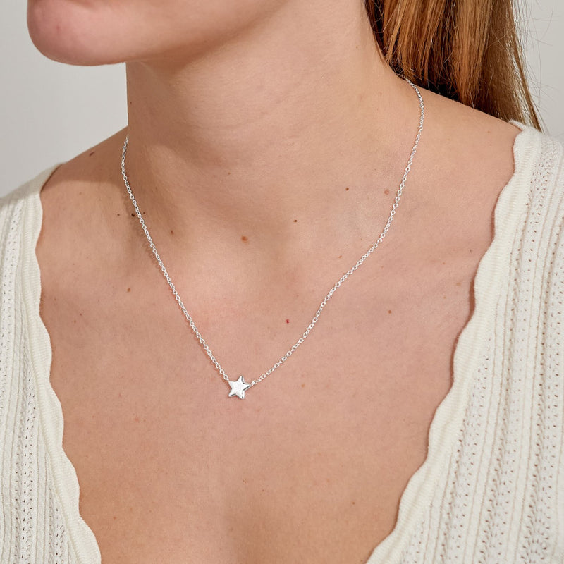 Delicate silver star necklace worn at collarbone – perfect minimal Christmas gift for her.
