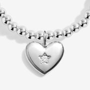 Close-up of Joma Peace Love Joy bracelet heart charm