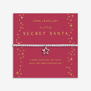 Gift display card for A Little “Secret Santa” bracelet – red and gold Christmas stars with merry message for seasonal gifting.

