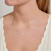 Minimal silver heart necklace resting at collarbone – everyday jewellery gift to show love.
