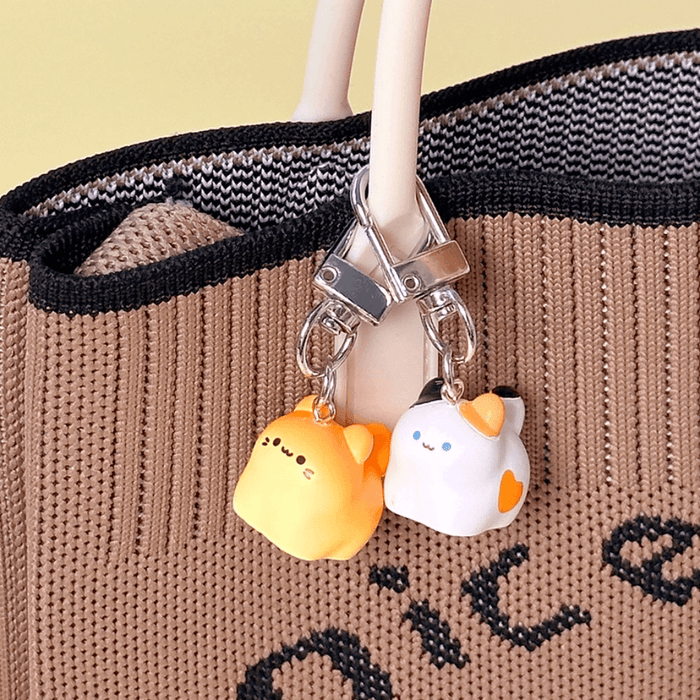 Kawaii Bread Cat Keychain Mystery Blind Box charms clipped onto a knitted tote bag