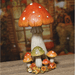 Lifestyle view of a tall autumn mushroom decoration on a wooden surface with a rustic backdrop.