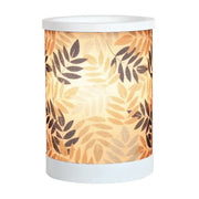 Leaves design electric wax melt burner switched on, glowing warmly through the leafy pattern.
