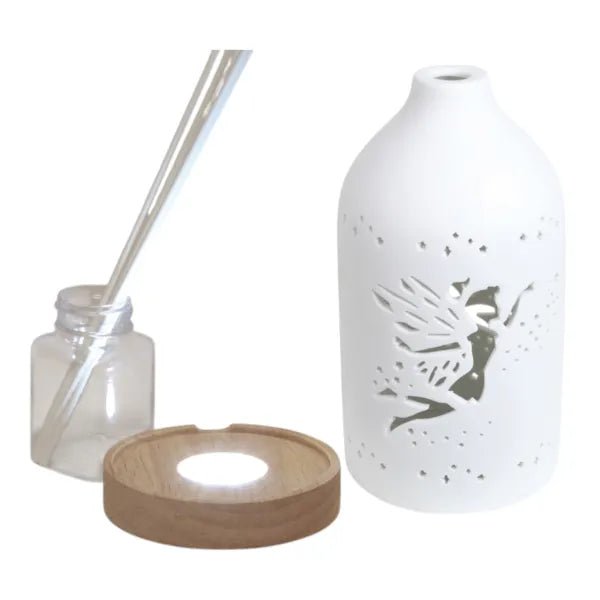 Disassembled fairy diffuser with ceramic cover, LED base, reed sticks, and bottle

