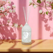 Fairy LED reed diffuser glowing on a table with pink background and cherry blossoms

