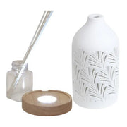 Disassembled reed diffuser with ceramic cover, base, glass bottle, and reed sticks

