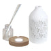 Disassembled reed diffuser with ceramic cover, base, glass bottle, and reed sticks

